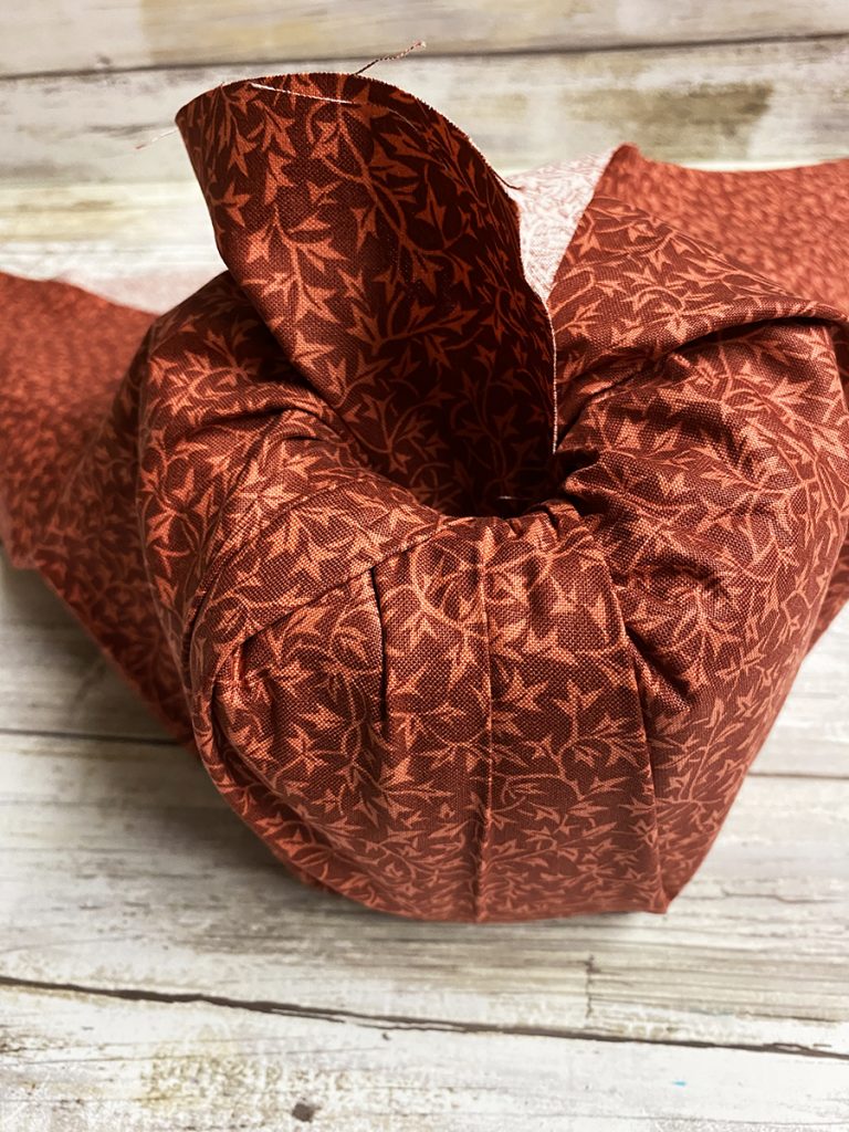 Tuck the fabric into the paper roll for the Quick and Easy No Sew Pumpkins
